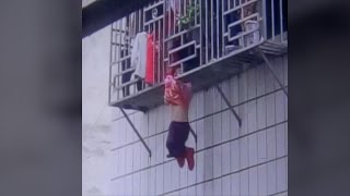 Footage: Two men save girl hanging by neck from fourth-story window