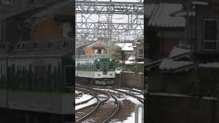 The 1000 series semi-express train of the Keihan makes a right turn on the snow-covered tracks.