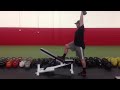 standing one arm kb overhead press with foot on bench