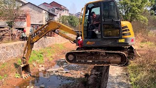 The small excavator passed the ditch, and the legs were shaking