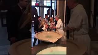 Niño se le cae a sacerdote en un bautizo