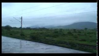 SAURASHTRA JANTA EXPRESS CAPTURED WITH CLOUDS HOVERING ABOVE THE MOUNTAIN RANGE