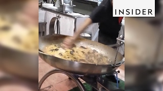 An Italian chef cooks seafood spaghetti in a giant pan