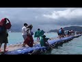 people walking on a swaying pontoon on racha island phuket thgailand