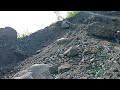 the process of lowering a large rock from the top of a hill.