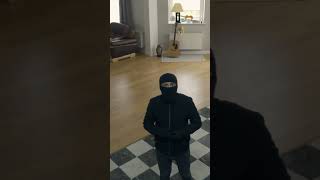 The Thief in Black Clothes and Balaclava Walking in the Large Living Room