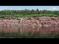 A woman is floating on a supboard along a rocky cliff.