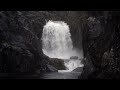 black rock waterfall glistening wet surroundings in a dimly lit gorge sleepsounds