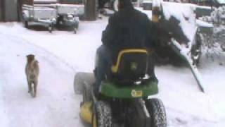 Sneeuw schuiven met John Deere zitmaaier