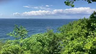 Bornholm, Denmark.  Lush green forest, azure Baltic Sea. Cycling the island of Bornholm.