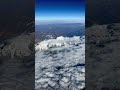 flying over the andes foothills to the snow capped mountains on our flight from lima to bogotá