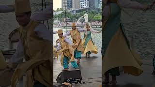 Folk dancers on stage with Merlion in the background in Singapore