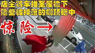 监控下惊险一幕！店主将车推至屋檐下，险些被掉落的棚顶砸中