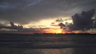 Layers of storm clouds, a flat sea and a pretty su