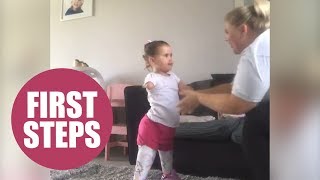 Cute amputee daughter takes first steps on prosthetic legs