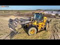 jcb loader with silage rake on a maize silage field clamp jcbloader