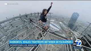 Daredevil walks tightrope between graffitied skyscrapers in downtown LA