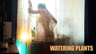 Transparent watering houseplants with model girl in a dress