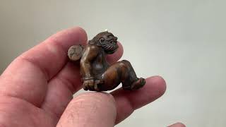 Antique wood netsuke with Raiden seated holding his gatas and his drum on his back.