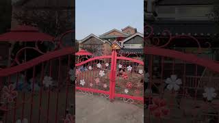 a beautiful house with a pretty red gate