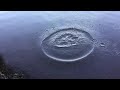 slow motion throwing a rock in water big ripples