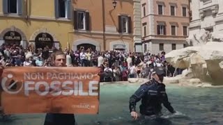 Climate change activists turn Trevi Fountain water black