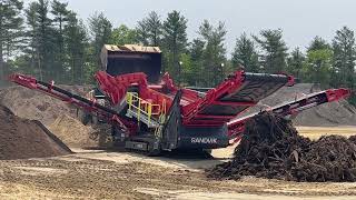 A Sandvik QE442 being fed by a 980 CAT on a job site