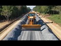 The village of a new road construction site, Operating  SDLG motor grader spreading pile gravel