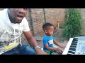 A two year old boy playing keyboard