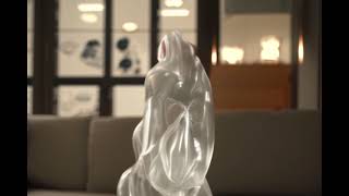Transparent Glass Cat Blinks on Cozy Couch