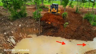 Big dozer cat pushing soil red into water delete pit working fast