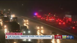 Snow falling on I-5 at the Grapevine, CHP pacing traffic