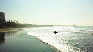 Surfer walking in the Pacific Beach Sunrise