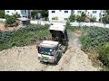 Dump truck unloading stone filling up with Bulldozer komatsu D31p Working push stone into the water