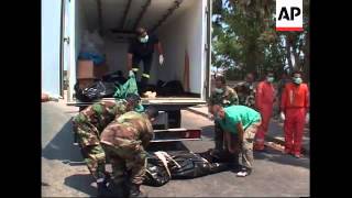 Relatives prepare coffins ahead of mass funeral; bodies arriving