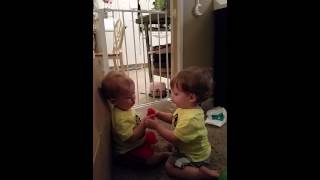 Twin brothers adorably share toys