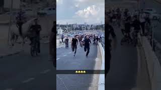 Meanwhile in Jerusalem: A friendly competition between a police officer and a local Arab.