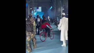Tyler The Creator riding through the Louis Vuitton fashion show on a bike in Paris