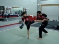 kru ash muaythai and striking coach doing some padwork with max laurin