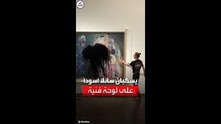 ناشطان بيئيان يرشان سائلاً أسود على لوحة \