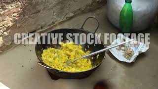 Close up of hand stirring wok on traditional clay stove  High shot  Bengal, India