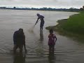 a rainy season catching fishes on river bank