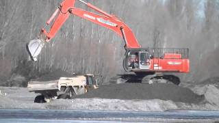 Hitachi EX550 Excavator loading Volvo dump trucks.