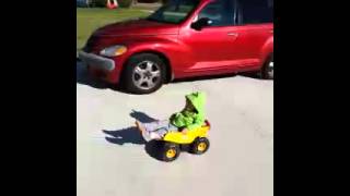 Kid rolls down driveway in tonka truck toy