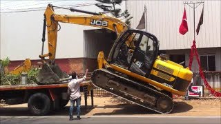 Dangerously unloading an excavator at roadside with heavy trafic