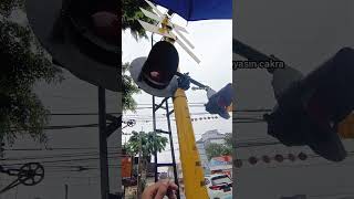 memegang lampu palang kereta api saat hujan deras railroad crossing jakarta