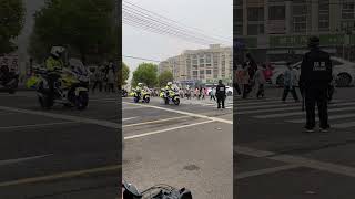 幼儿园小朋友排队过马路，交警挡在机动车前暖心护送。    The children cross the road, and the traffic police warmly escort them.