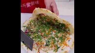 Egg-filled pancake（鸡蛋灌饼）is a popular delicacy in China.  Location: Zhengzhou Zhongyuan, District.