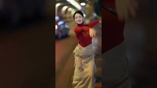 A beautiful Tibetan girl gracefully dancing in a square dance in China.