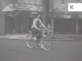 1950s uk girl rides bicycle along suburban street